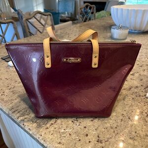 NWOT; Authentic LOUIS VUITTON Vernis Bellevue PM in Amarante. Perfect condition.
